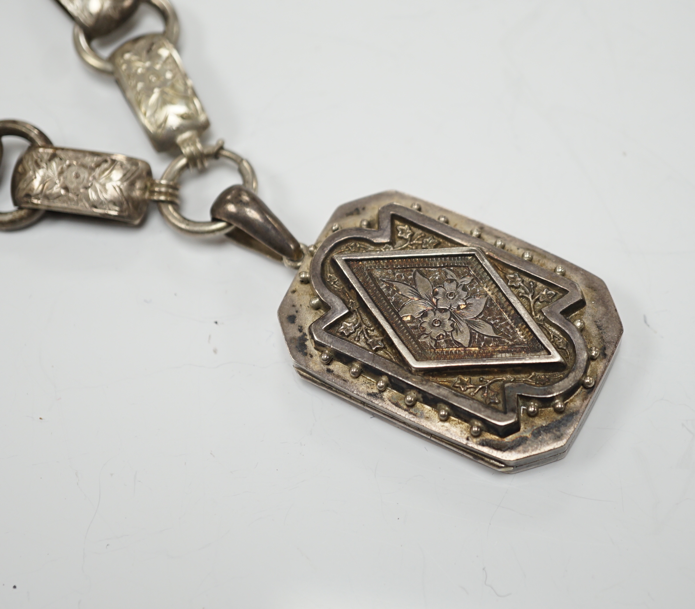 A Victorian silver octagonal locket, Chester, 1880, 44mm, on an engraved white metal chain.
